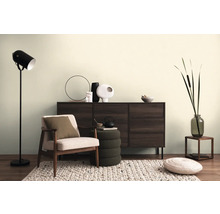 Obývacia izba s kreslom, komodou, stojacou lampou a dekoratívnymi doplnkami pre útulnú atmosféru