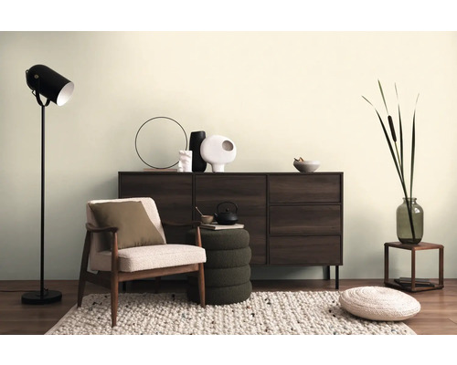 Obývacia izba s kreslom, komodou, stojacou lampou a dekoratívnymi doplnkami pre útulnú atmosféru