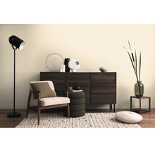 Obývacia izba so skrinkou, kreslom, stojacou lampou a dekoratívnymi prvkami na koberci