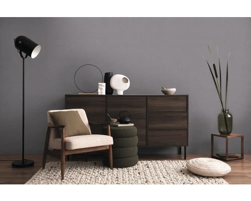 Obývacia izba s kreslom, stojacou lampou a komodou pre útulnú atmosféru