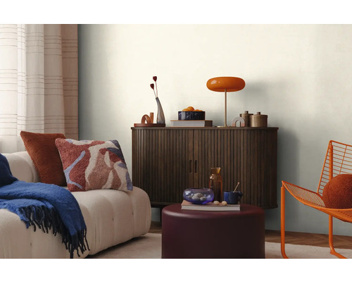 Interiér obývacej izby s pohovkou, skrinkou, lampou a dekoráciou