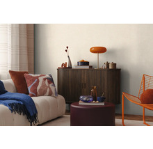 Obývacia izba s pohovkou, vankúšmi, dekou, skrinkou, lampou a dekoráciou pre útulnú atmosféru