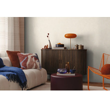 Obývacia izba s pohovkou, komodou, lampou a dekoráciou pre útulnú atmosféru