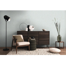 Obývacia izba s komodou, kreslom, stojacou lampou a dekoratívnymi prvkami pre útulnú atmosféru