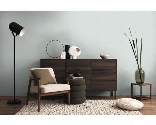 Obývacia izba s komodou, kreslom, stojacou lampou a dekoratívnymi prvkami pre útulnú atmosféru