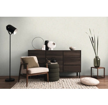 Obývacia izba s kreslom, komodou, stojacou lampou a dekoráciami pre útulnú atmosféru.