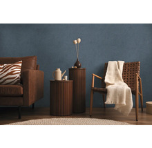 Obývacia izba s pohovkou, kreslom, príručnými stolíkmi a dekoráciami na modrej štruktúrovanej tapete