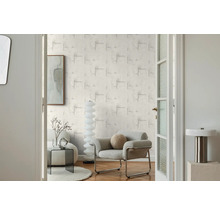 Obývacia izba s vzorovanou tapetou, kreslom a dekoráciou