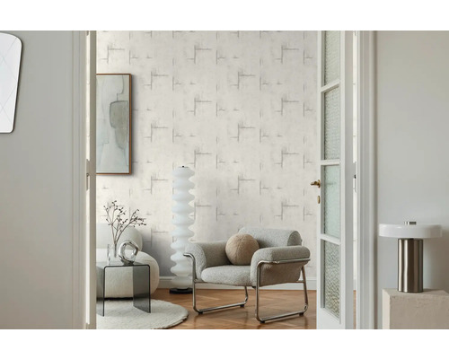 Obývacia izba s vzorovanou tapetou, kreslom a dekoráciou