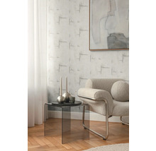 Obývacia izba s kreslom, odkladacím stolíkom a vzorovanou tapetou