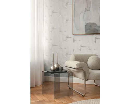 Obývacia izba s kreslom, odkladacím stolíkom a vzorovanou tapetou