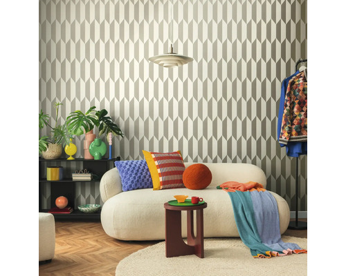 Obývacia izba s geometrickou tapetou, pohovkou, odkladacím stolíkom a dekoratívnymi prvkami pre štýlové prostredie.