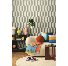 Obývacia izba so vzorovanou tapetou, pohovkou, odkladacím stolíkom a dekoráciami pre útulnú atmosféru.