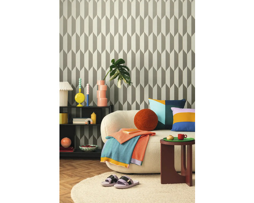 Obývacia izba so vzorovanou tapetou, pohovkou, odkladacím stolíkom a dekoráciami pre útulnú atmosféru.