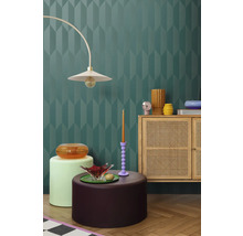 Interiér s dekoratívnou stenou, lampou, komodou a dekoratívnymi prvkami pre štýlové prostredie.