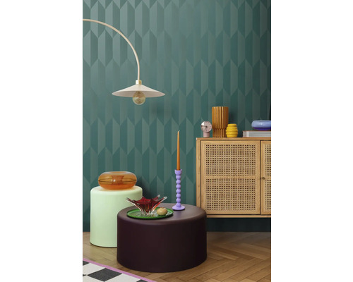 Interiér s dekoratívnou stenou, lampou, komodou a dekoratívnymi prvkami pre štýlové prostredie.