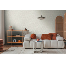 Svetlá obývacia izba so vzorovanou tapetou, pohovkou, kobercom a drevenou policou