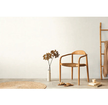 Svetlý interiér s drevenou stoličkou, dekoráciou a textilom