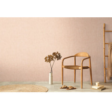 Dekoratívne obytné prostredie s drevenou stoličkou, kobercom a izbovou rastlinou na pozadí decentnej steny