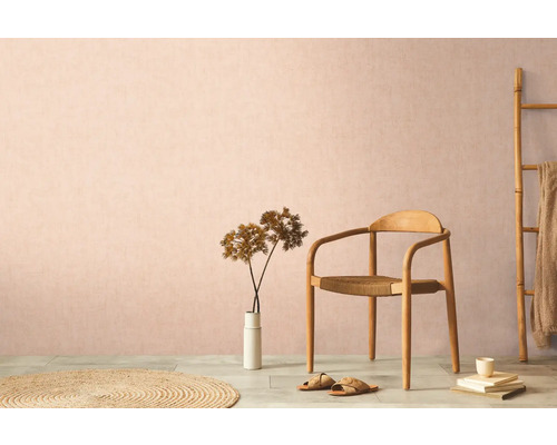 Dekoratívne obytné prostredie s drevenou stoličkou, kobercom a izbovou rastlinou na pozadí decentnej steny