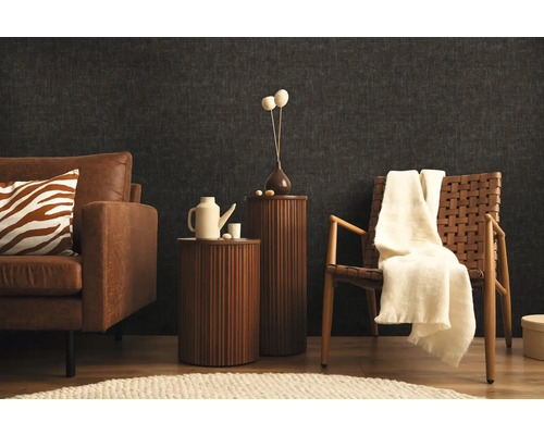 Obývacia izba s pohovkou, kreslom a príručnými stolíkmi pred tmavou stenou