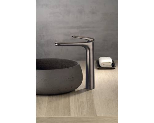 Umývadlová batéria vedľa umývadla na dosku na drevenom povrchu