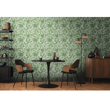 Jedáleň so stolom, stoličkami a regálom pred zelenou tapetou s listami