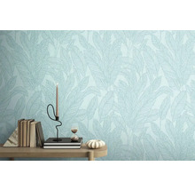 Detail steny s tapetou so vzorom listov, zdobené knihami, sviečkou a presýpacími hodinami