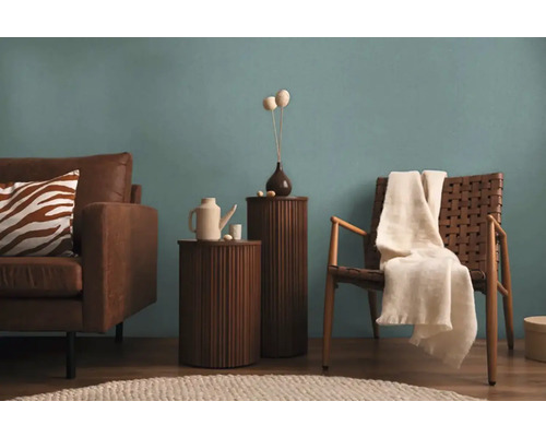 Obývacia izba s hnedou koženou sedačkou, dreveným stolom, ratanovým kreslom a dekoráciou