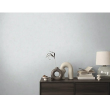 Dekoratívna komoda s vázami, knihami a lampou pred svetlou stenou