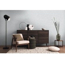 Obývacia izba s komodou, kreslom, stojacou lampou a dekoratívnymi prvkami pre útulnú atmosféru