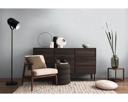 Obývacia izba s komodou, kreslom, stojacou lampou a dekoratívnymi prvkami pre útulnú atmosféru