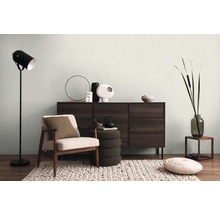 Obývacia izba s kreslom, komodou, stojacou lampou a dekoráciou pre útulnú atmosféru.