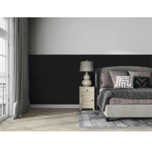 Spálňa s posteľou, nočným stolíkom a lampou pred stenou s dreveným obkladom