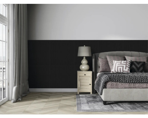 Spálňa s posteľou, nočným stolíkom a lampou pred stenou s dreveným obkladom