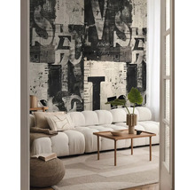 Obývacia izba s pohovkou, konferenčným stolíkom a tapetou s novinovou potlačou