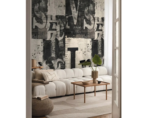 Obývacia izba s pohovkou, konferenčným stolíkom a tapetou s novinovou potlačou
