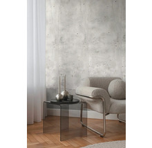 Dekoratívna izba s fototapetou v betónovom vzhľade, kreslom a odkladacím stolíkom