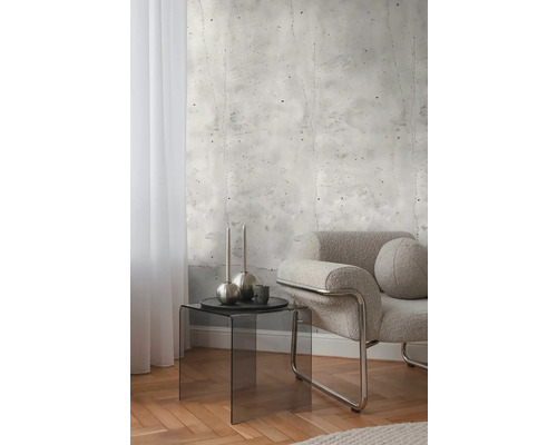 Dekoratívna izba s fototapetou v betónovom vzhľade, kreslom a odkladacím stolíkom