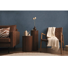 Obývacia izba s pohovkou, kreslom, príručnými stolíkmi a dekoráciou pred modrou stenou