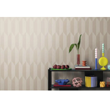 Obývacia izba so vzorovanou tapetou a dekoratívnymi predmetmi na polici