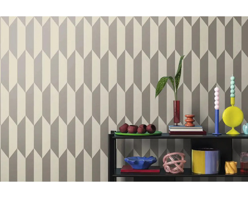 Stena s geometrickou tapetou a dekoratívnymi predmetmi na polici