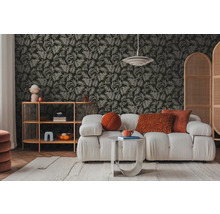 Obývacia izba s pohovkou, regálom a tapetou so vzorom listov