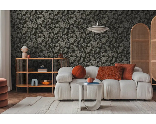 Obývacia izba s pohovkou, regálom a tapetou so vzorom listov