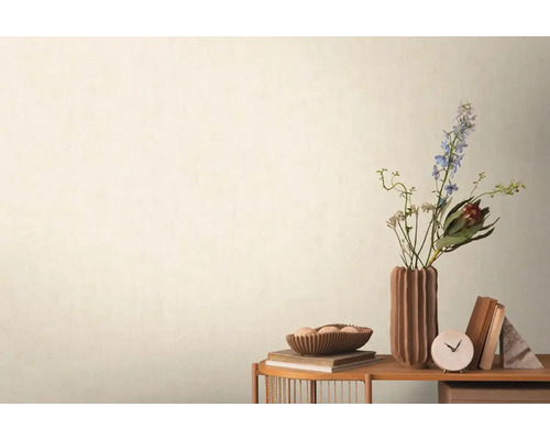 Dekoratívna scéna s kvetmi, knihami a stolovými hodinami na odkladacom stolíku pred stenou