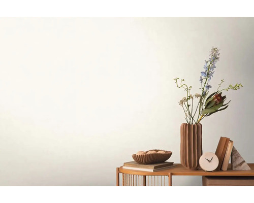 Dekoratívna scéna s kvetmi vo váze, miskou, knihami a hodinami na stole