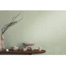 Dekoratívna scéna s vázou, konármi a rôznymi predmetmi na stole pred stenou