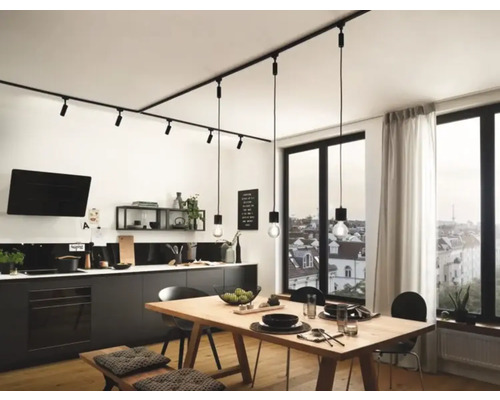 Moderná kuchyňa s čiernou kuchynskou linkou, dreveným stolom a čiernym koľajnicovým systémom s bodovými a závesnými svietidlami