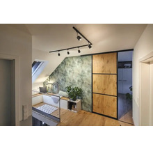 Svetlý podkrovný byt so strešným oknom, posedením, zelenou tapetou s motívom listov, posuvnými dverami a drevenou podlahou.