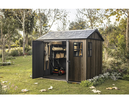 Záhradná búda s otvorenými dverami v záhrade, plná záhradného náradia